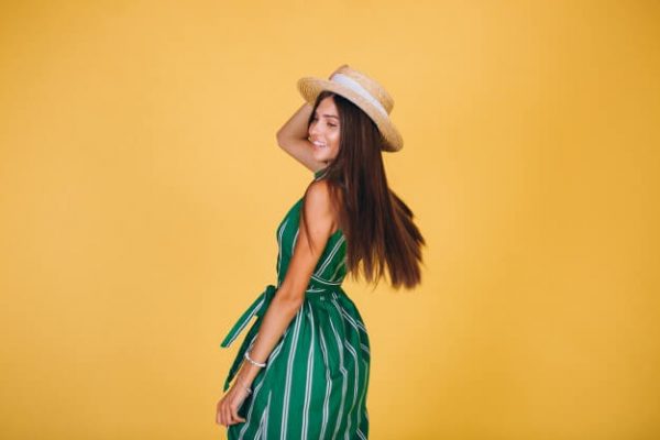 woman-green-dress-hat-yellow-background_1303-10554